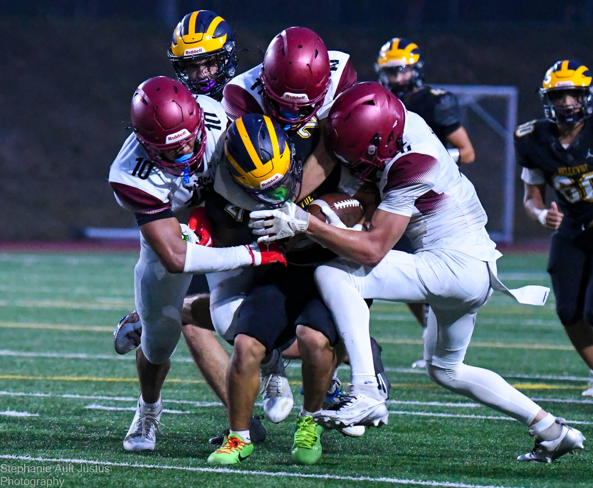 Bethel's defense in action: tackling Bellevue's Max Jones with combined efforts from Zak Fruean, Jayden Miller, and Mason Dutcher.